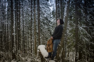 Caucasian hiker standing in snowy forest