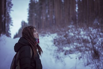 Caucasian woman standing in snowy forest