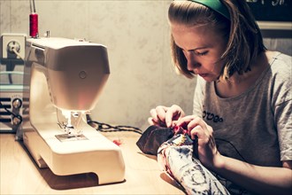 Caucasian woman using sewing machine
