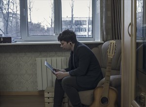 Caucasian man reading digital tablet in living room