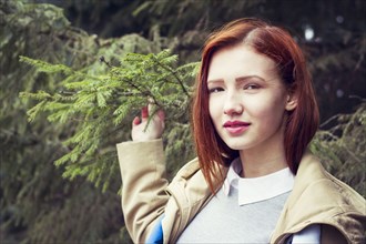 Woman with red hair holding tree branch