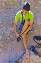 Hispanic man preparing for rock climbing
