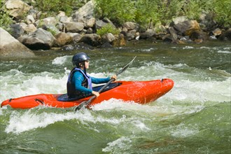 Caucasian girl kayaking in river