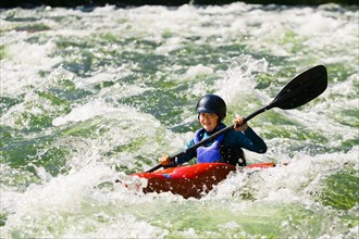 Caucasian girl kayaking in river