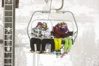 Friends riding ski lift