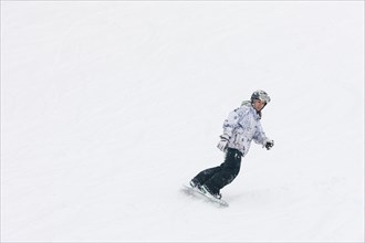 Chinese snowboarder descending ski slope