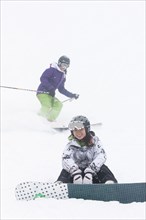 Skier and snowboarder on ski slope