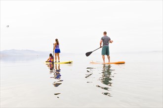 Family riding paddle boards