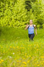 Caucasian woman running in tall grass