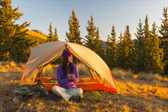 Mixed race woman camping in rural landscape