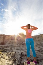 Woman standing in canyon stretching arms