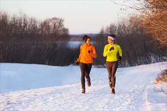 Women running on snow in winter