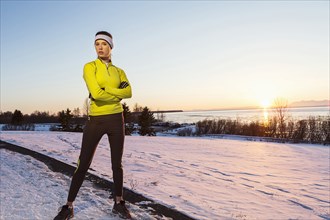 Caucasian runner posing with arms crossed in winter