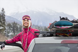 Caucasian woman posing at car with snowboards