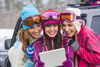 Women posing for selfie with digital tablet in winter
