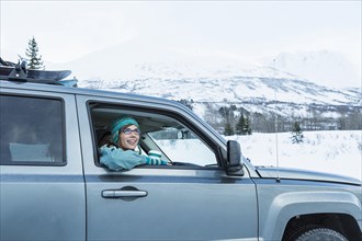 Caucasian woman  leaning in car window in winter