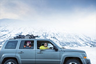 Friends enjoying scenic view from car in winter