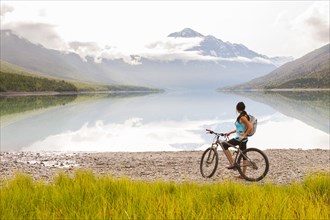 Mixed Race woman riding a bicycle near lake