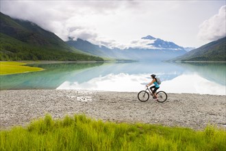 Mixed Race woman riding bicycle near lake