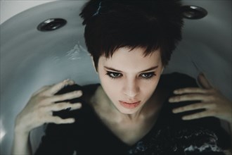 Caucasian woman wearing dress in bathtub