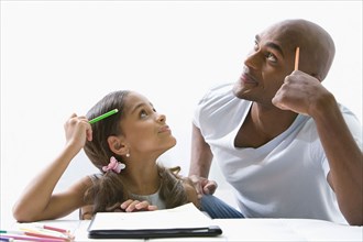 Mixed race father helping daughter with homework