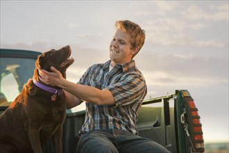 Caucasian man sitting in truck with dog