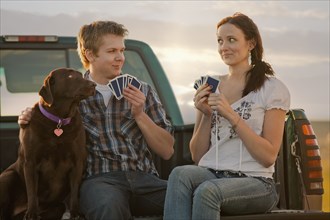 Caucasian couple playing cards in truck