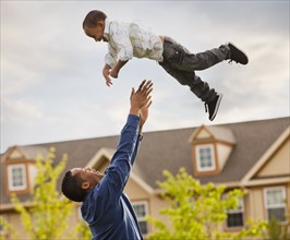 Father throwing son into the air