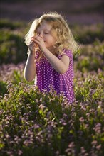 Caucasian girl smelling flowers