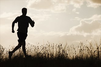 Caucasian man running at sunset