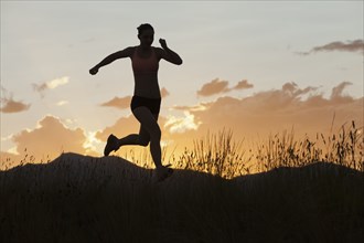 Caucasian woman running in remote area at sunset