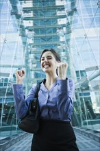 Caucasian businesswoman cheering outdoors