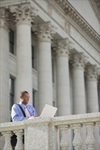 Black businessman using laptop outdoors