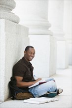 Black college student doing homework outdoor