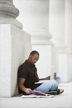 Black college student doing homework outdoors