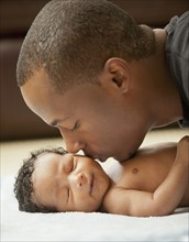 Father kissing newborn baby