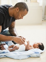 Father changing newborn baby's diaper