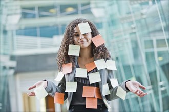 Caucasian businesswoman covered in sticky notes