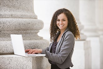 Caucasian businesswoman using laptop outdoors