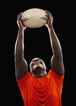 African American man holding rugby ball