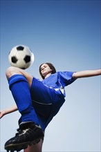 Caucasian woman kneeing soccer ball