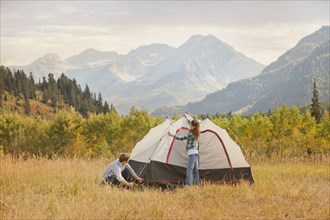 Caucasian couple setting up tent