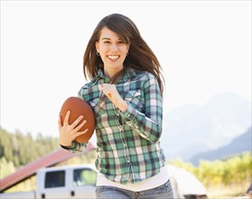 Caucasian woman running with football