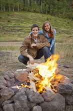 Caucasian couple enjoying campfire