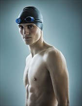 Caucasian teenage boy in swim cap and goggles