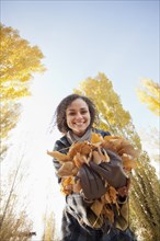 Caucasian woman holding autumn leaves