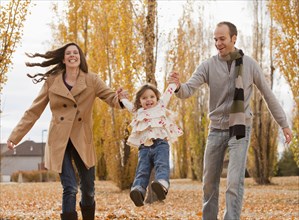 Caucasian family playing in autumn leaves