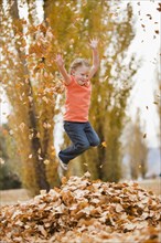 Caucasian girl playing in autumn leaves