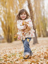 Caucasian girl playing with autumn leaves