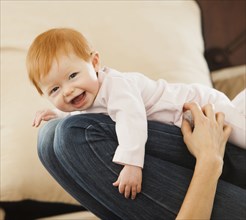 Caucasian mother playing with baby daughter